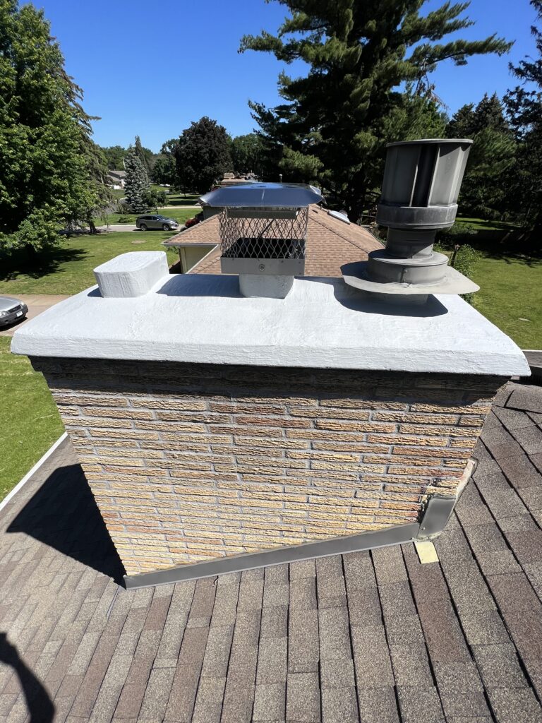 Chimney after chimney and fireplace services with a top damper rain cap installed, waterproofing on the brick, and waterproofing on the crown.