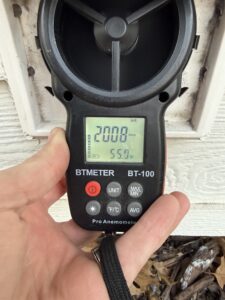 An anemometer tool measuring the airflow from a dryer vent exhaust after a dryer vent cleaning
